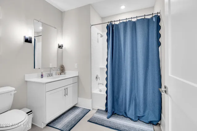 a bathroom with a sink a toilet a mirror and shower