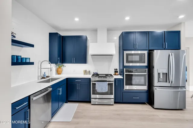 a kitchen with stainless steel appliances granite countertop a refrigerator stove a sink and dishwasher