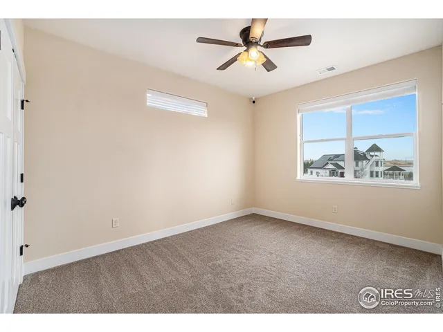 an empty room with a window and a ceiling fan