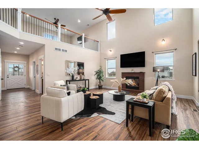 a living room with furniture a flat screen tv and a fireplace