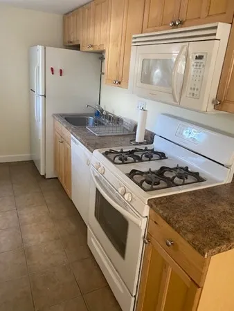 a white stove top oven sitting inside of a kitchen