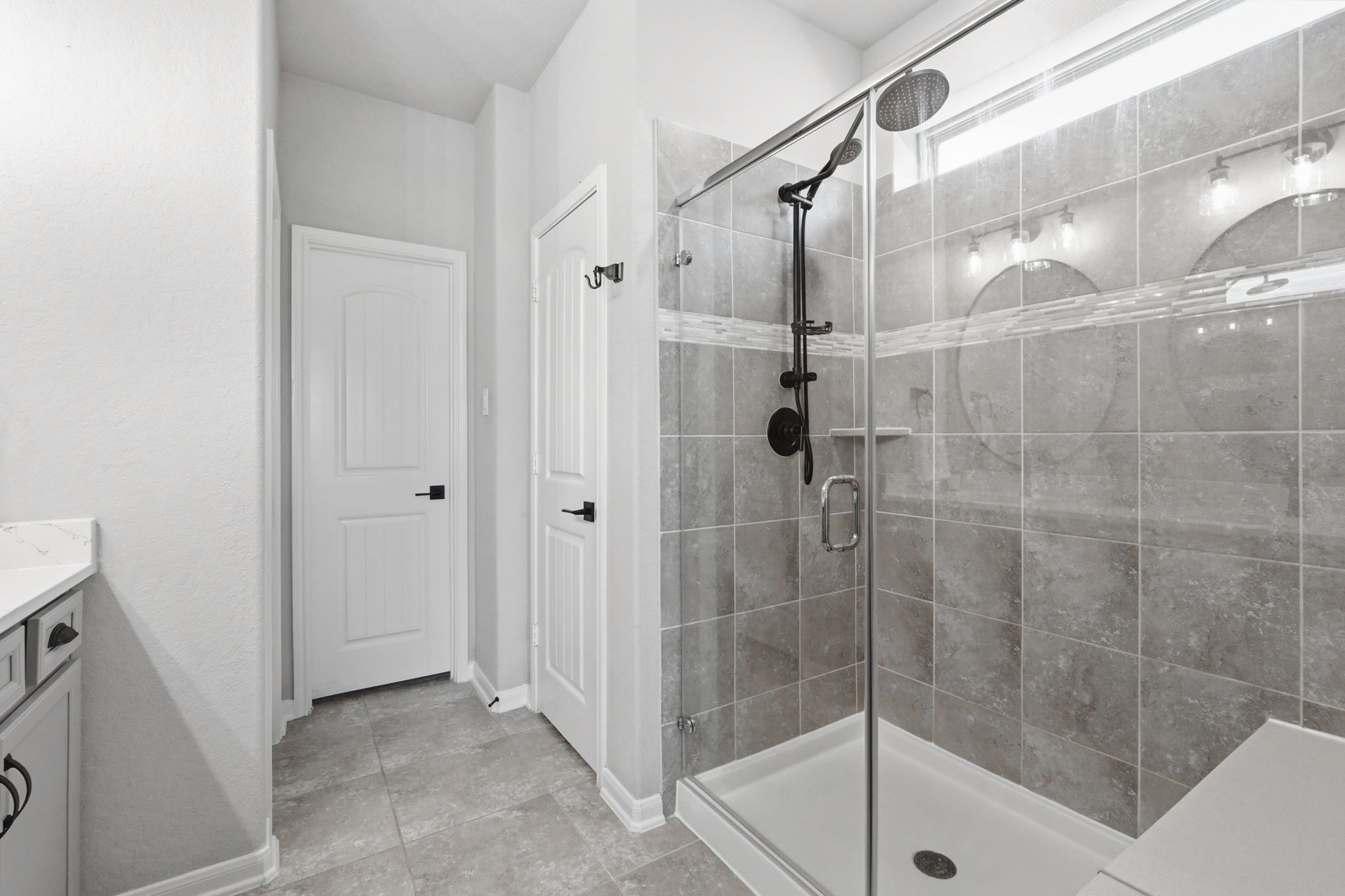 4334 Umber Shadow Drive Spring, TX 77386 - Photo 17 of 45 Walk-in shower showcases full-height tile surrounds, a frameless glass enclosure, and modern fixtures with a clean, contemporary design.