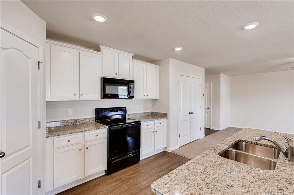3421 Ellingford Road Charlotte, NC 28214 - Photo 7 of 16 a kitchen with granite countertop a sink stove and cabinets
