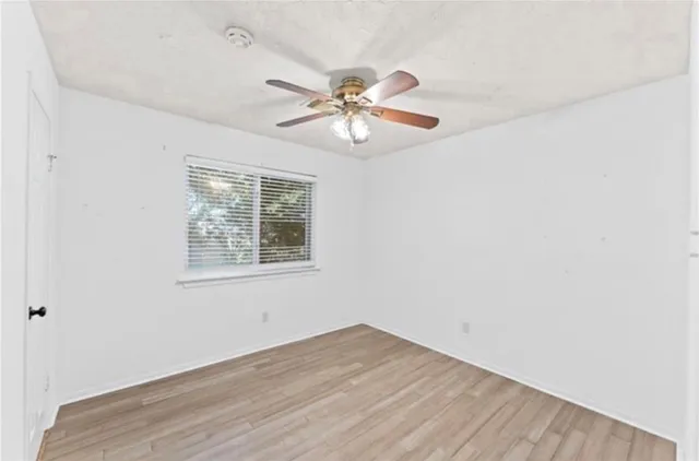 a view of a room with wooden floor and a ceiling fan