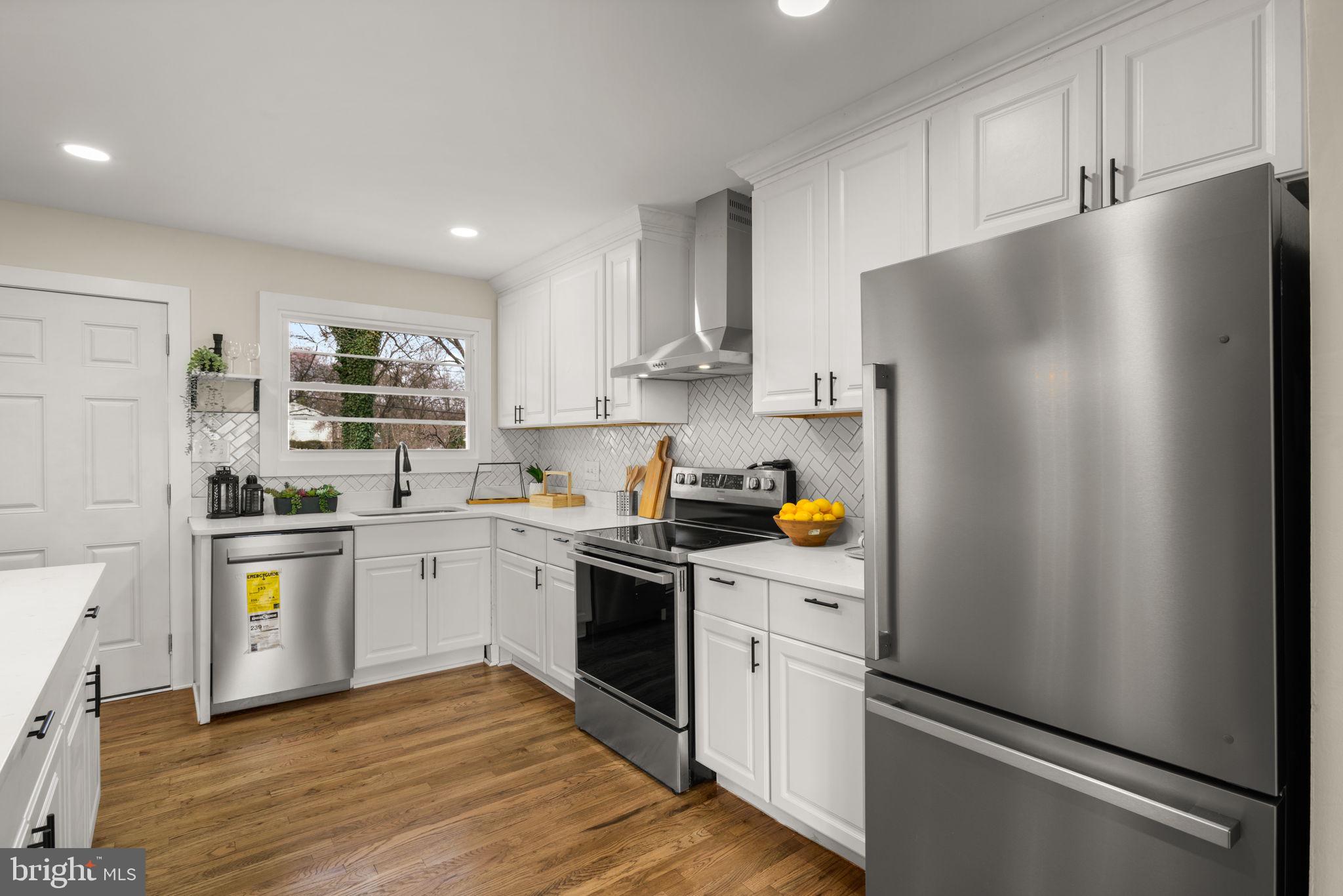3908 Rayton Road Randallstown, MD 21133 - Photo 12 of 42 a kitchen with stainless steel appliances a refrigerator sink and white cabinets