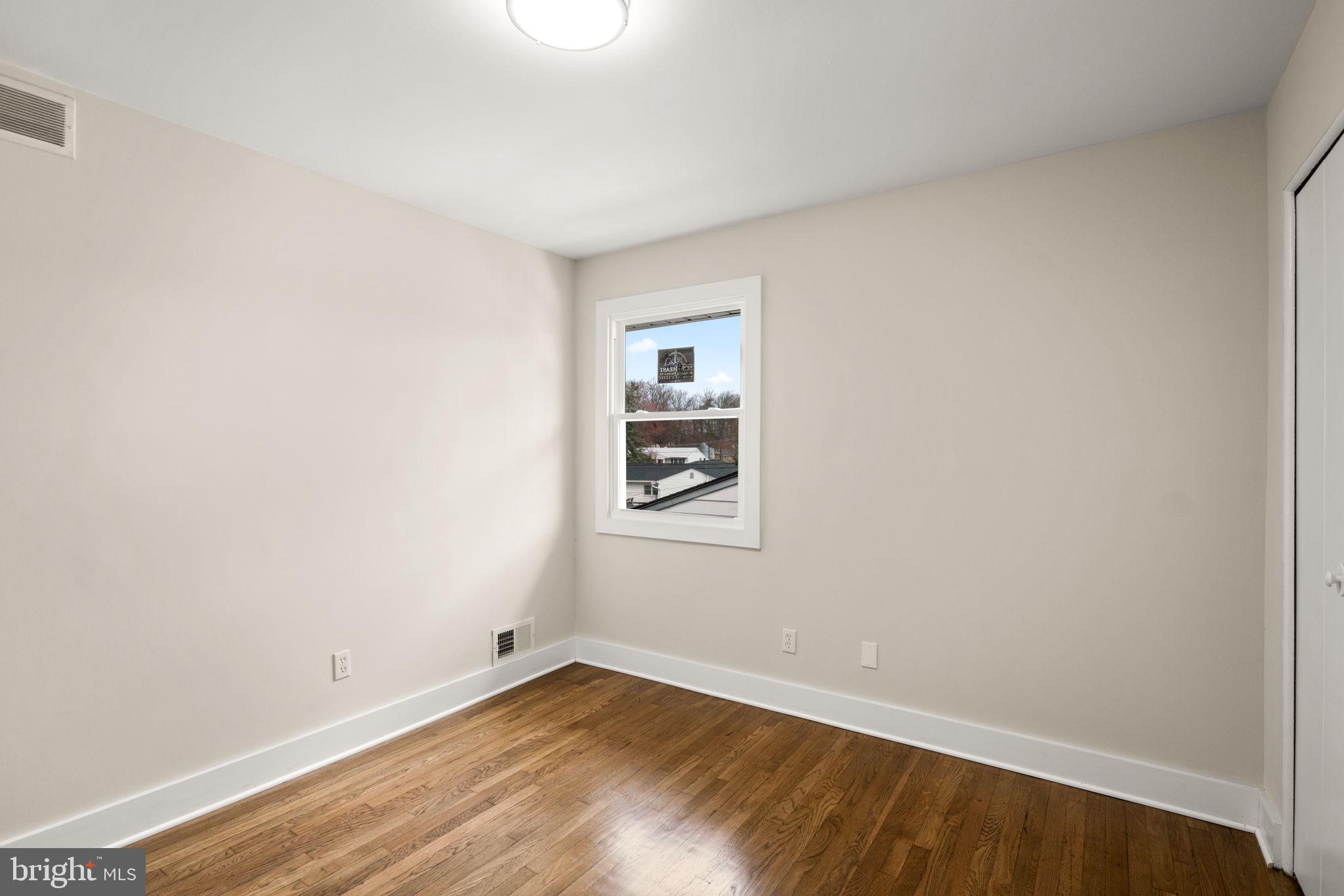 3908 Rayton Road Randallstown, MD 21133 - Photo 19 of 42 a view of an empty room with wooden floor and a window