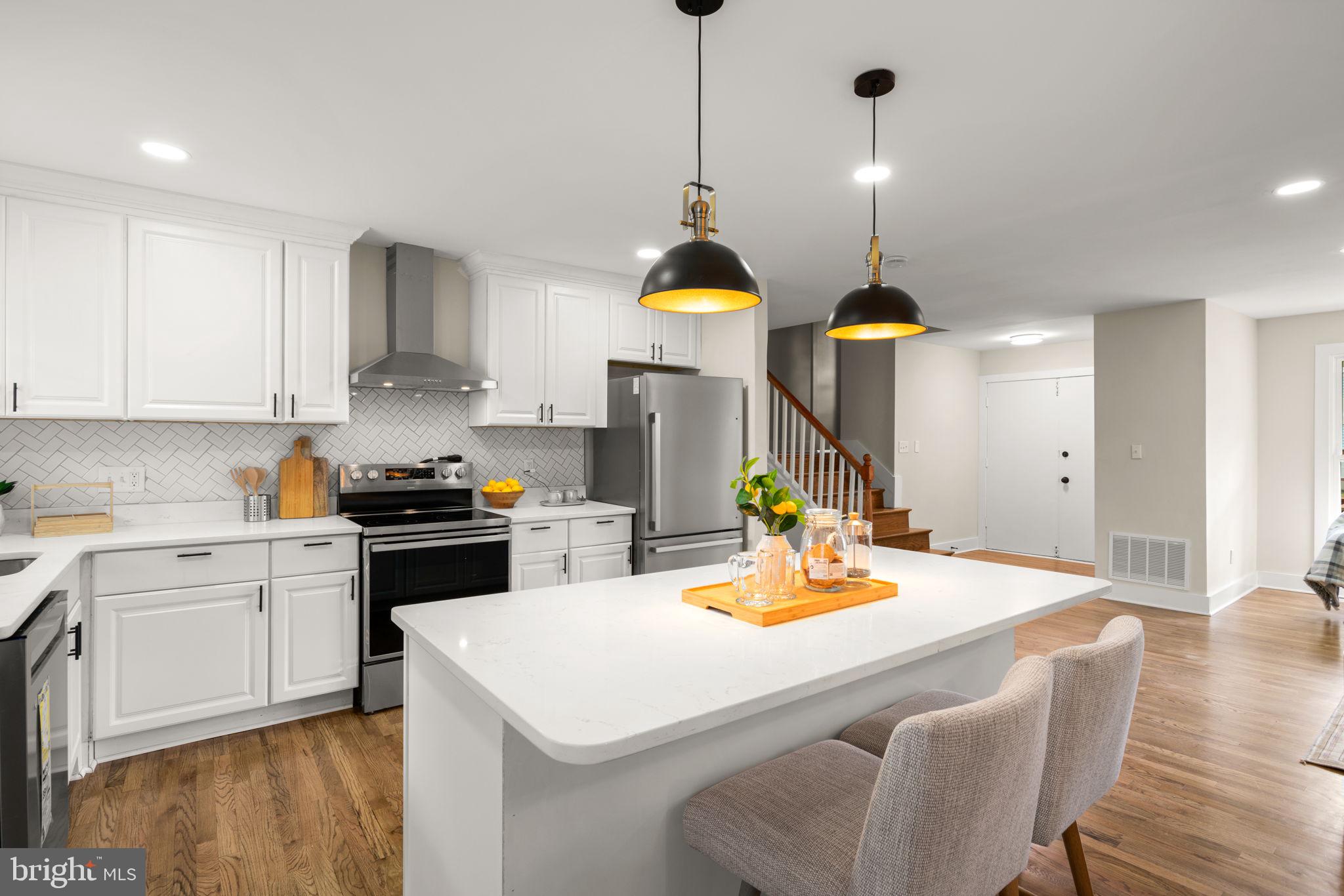 3908 Rayton Road Randallstown, MD 21133 - Photo 10 of 42 a kitchen with a sink a stove and chairs