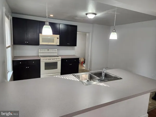 a kitchen with stainless steel appliances granite countertop a sink a stove and a refrigerator