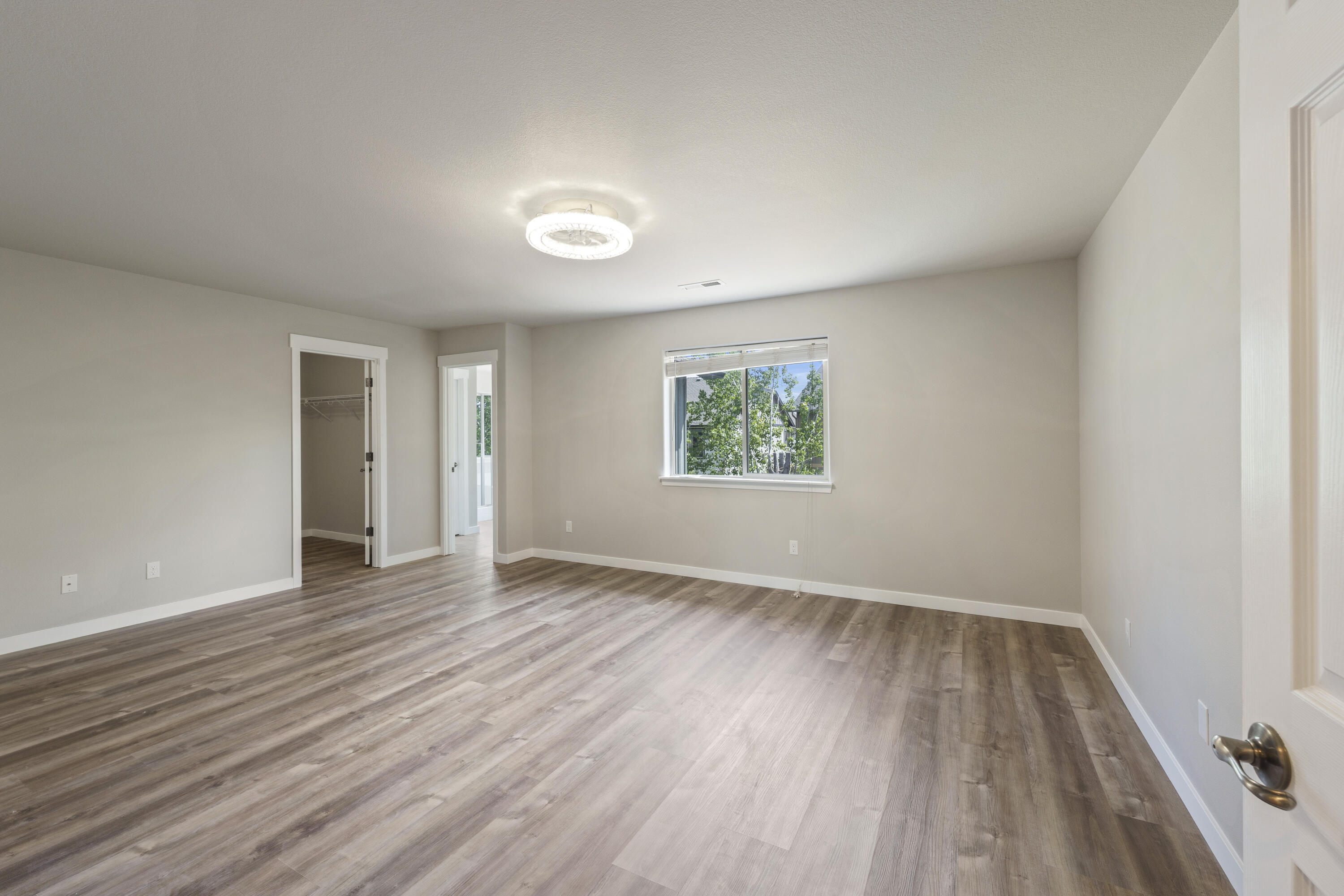 21189 Ritz Place Bend, OR 97702 - Photo 24 of 37 an empty room with wooden floor and windows