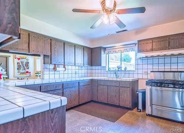 a kitchen with kitchen island granite countertop a sink cabinets and stainless steel appliances