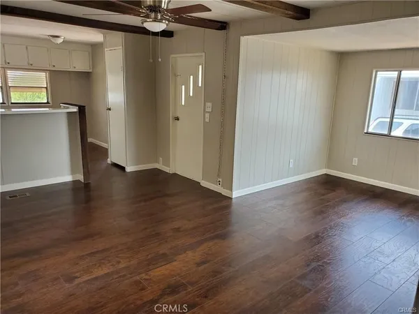 an empty room with wooden floor and a window
