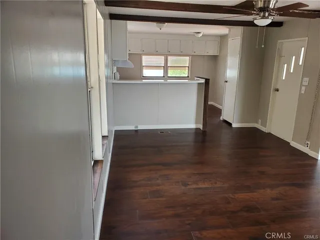a view of a hallway with wooden floor and a cabinet