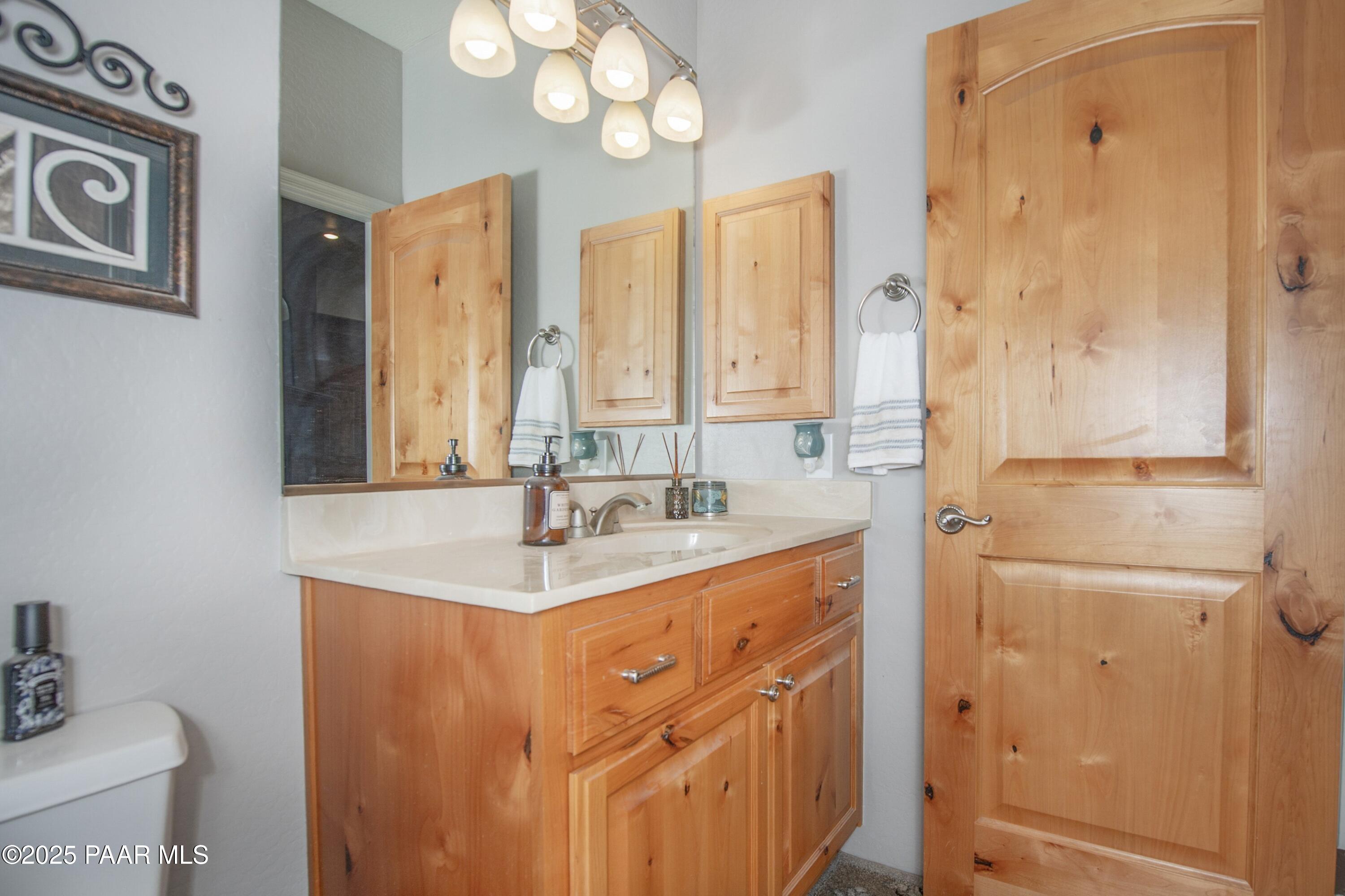 171 Enchanted Road Dewey, AZ 86327 - Photo 27 of 62 a bathroom with a granite countertop sink a mirror and a shower