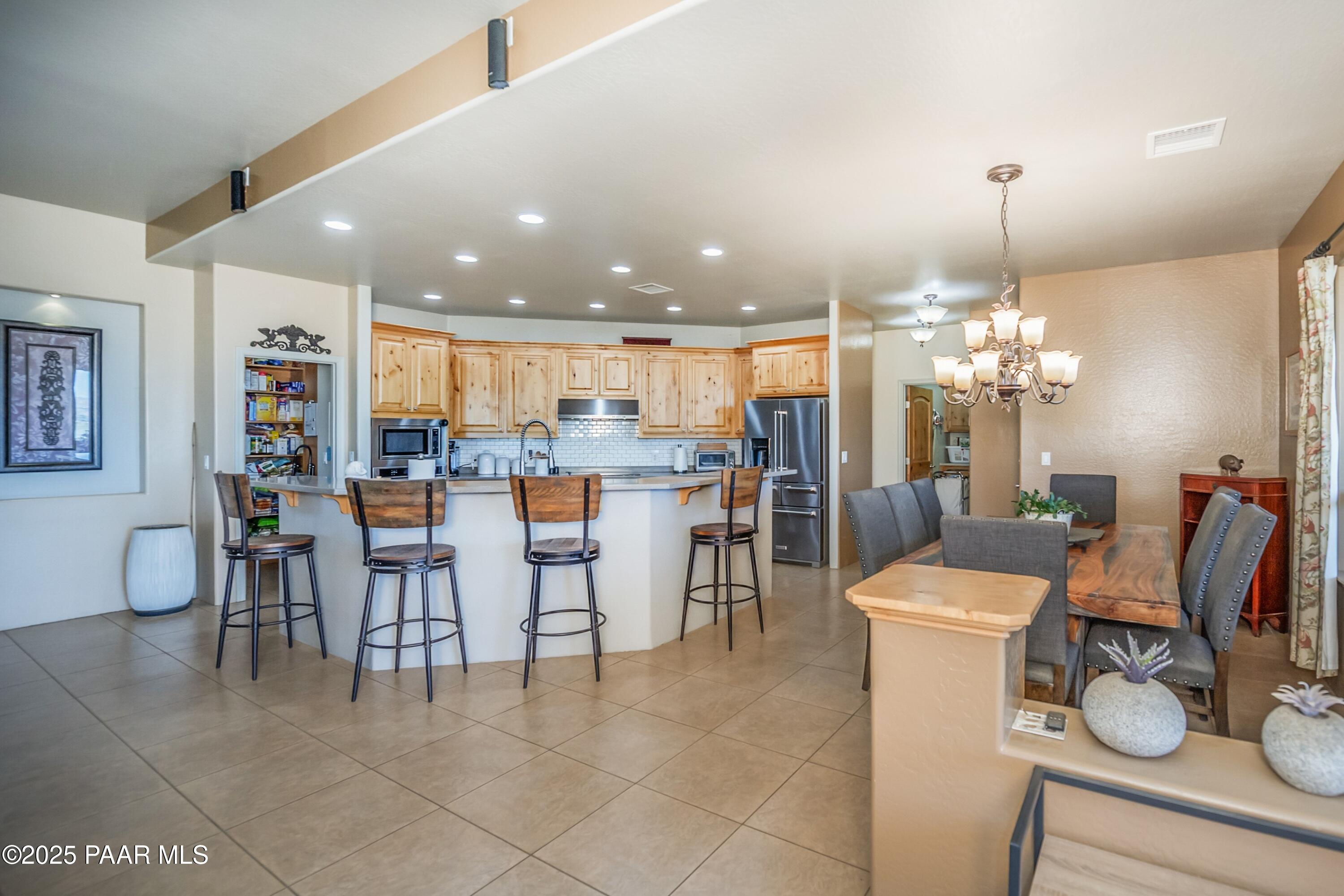 171 Enchanted Road Dewey, AZ 86327 - Photo 7 of 62 a dining room with furniture a chandelier and kitchen view