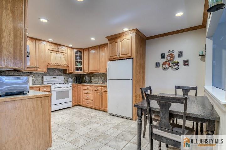16 Pendleton Place Old Bridge, NJ 08857 - Photo 6 of 30 a kitchen with stainless steel appliances granite countertop a refrigerator a stove a sink a dining table and chairs with wooden floor