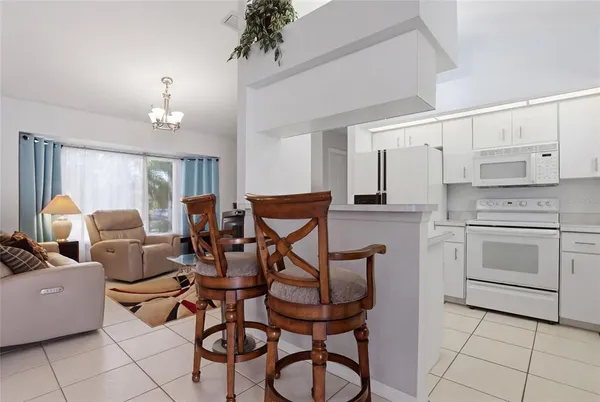 a very nice looking open dining room with kitchen island furniture and a chandelier
