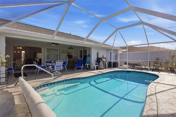 a view of a swimming pool with chairs in patio
