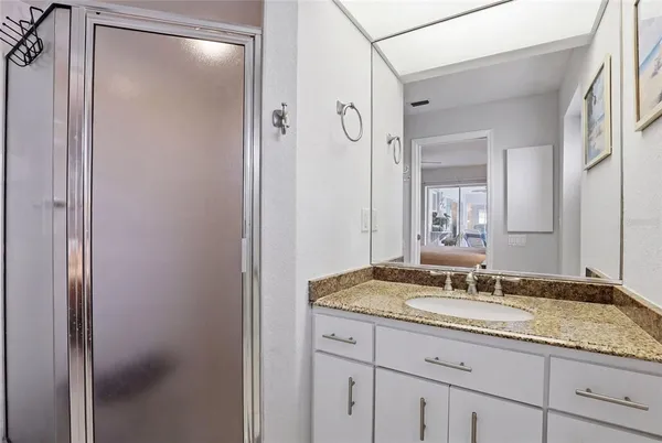 a bathroom with a granite countertop sink and a mirror