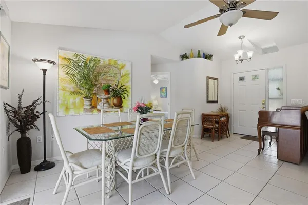 a view of a dining room with furniture and a chandelier fan