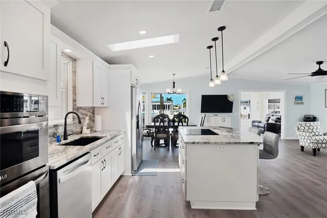 a kitchen with stainless steel appliances kitchen island granite countertop a sink and cabinets