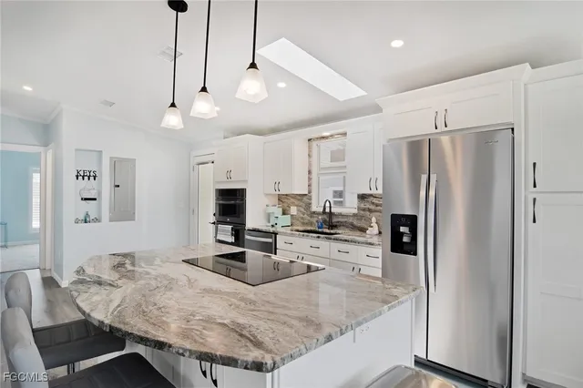 a kitchen with stainless steel appliances granite countertop a sink refrigerator and cabinets