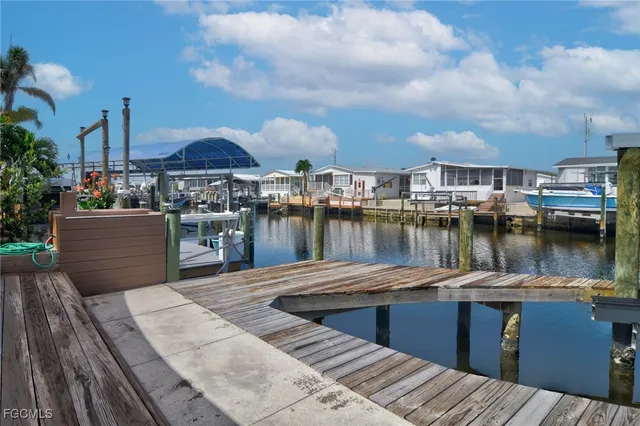 a lake view with a table and chairs next to a yard
