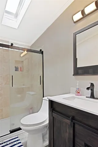 a bathroom with a sink a toilet a mirror and shower
