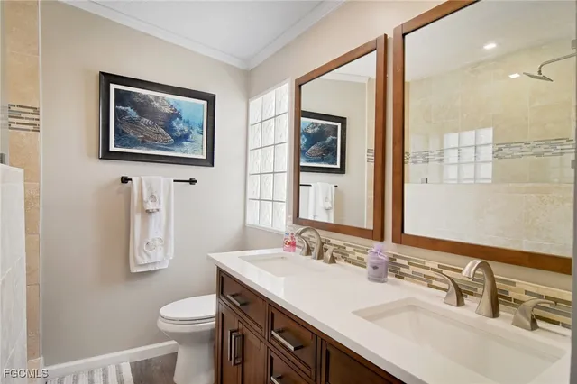 a bathroom with a toilet a sink a mirror a vanity and shower