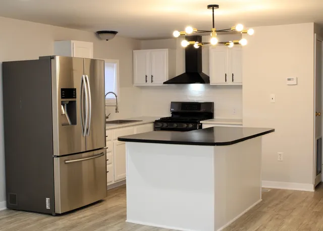 a kitchen with stainless steel appliances granite countertop a refrigerator a stove a microwave and a refrigerator