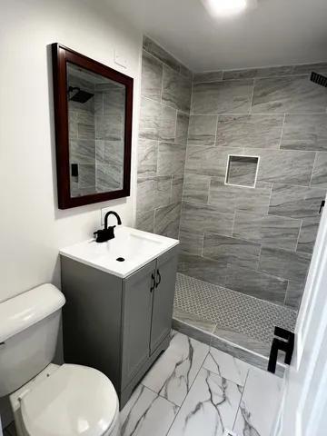 a bathroom with a sink and mirror with toilet