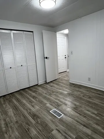 an empty room with wooden floor and window