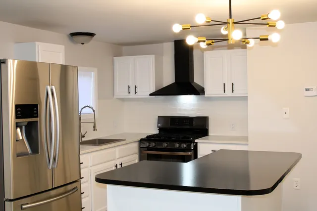 a kitchen with stainless steel appliances granite countertop a sink a refrigerator a stove a microwave and cabinets