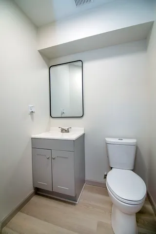 a bathroom with a toilet sink and mirror