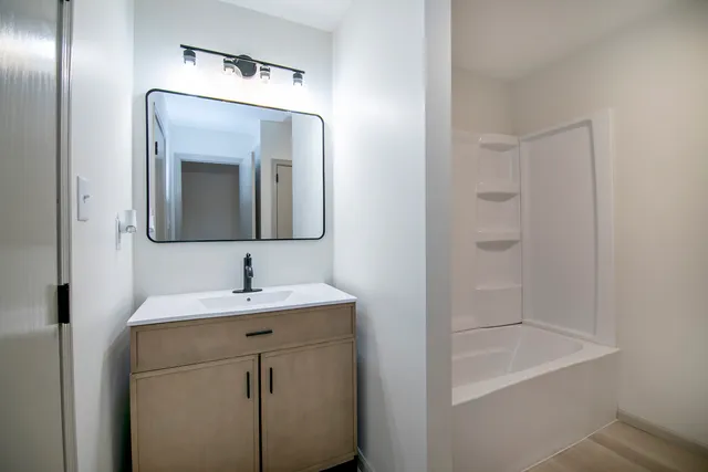 a bathroom with a sink a mirror and vanity