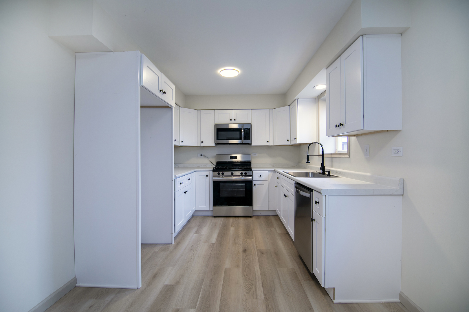 1320 South 3rd Avenue Kankakee, IL 60901 - Photo 7 of 19 a kitchen with granite countertop a stove top oven a sink dishwasher and a refrigerator with wooden floor