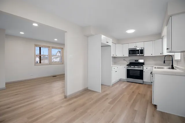 a kitchen with granite countertop a refrigerator and a stove top oven