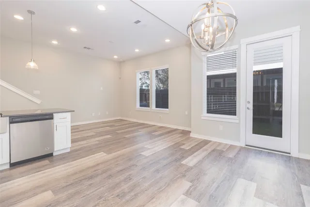 a view of empty room with wooden floor and window