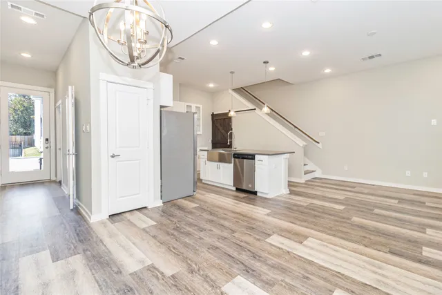 an empty room with wooden floor and hallway
