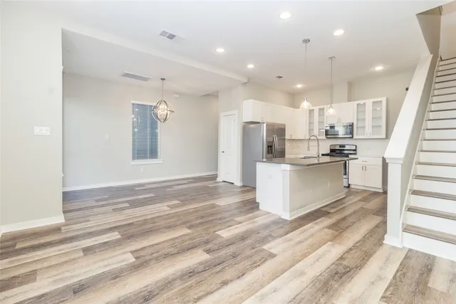 a view of kitchen with kitchen island white cabinets and stainless steel appliances