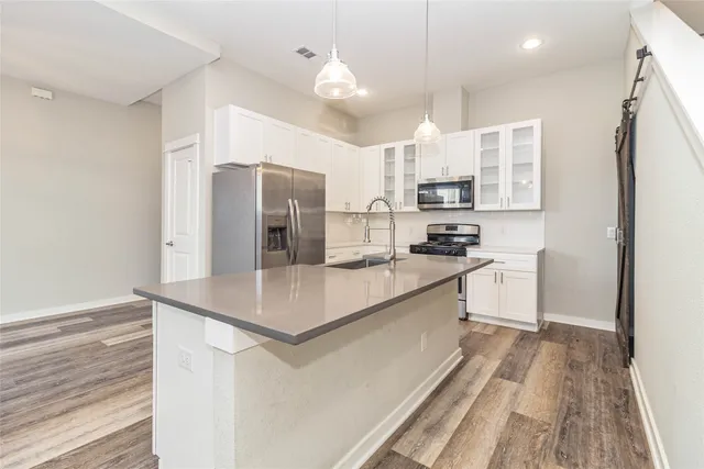 a kitchen with stainless steel appliances a refrigerator sink and microwave