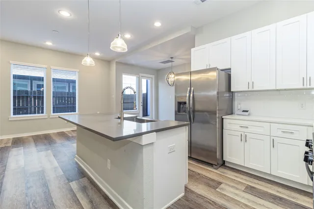 a kitchen with stainless steel appliances kitchen island granite countertop a refrigerator and a stove