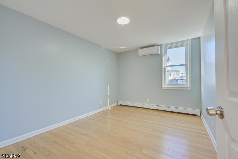 34 Tillman Street Raritan, NJ 08869 - Photo 19 of 31 an empty room with a wooden floor and windows