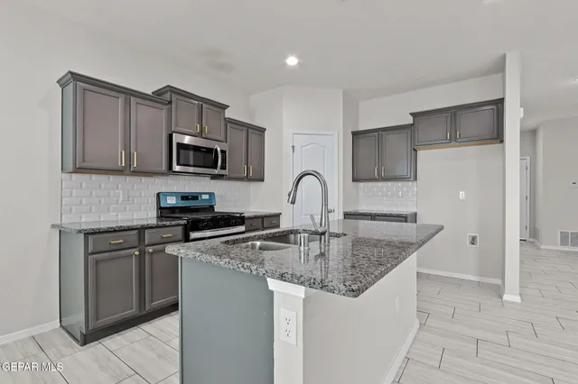 a kitchen with stainless steel appliances granite countertop a sink stove and refrigerator