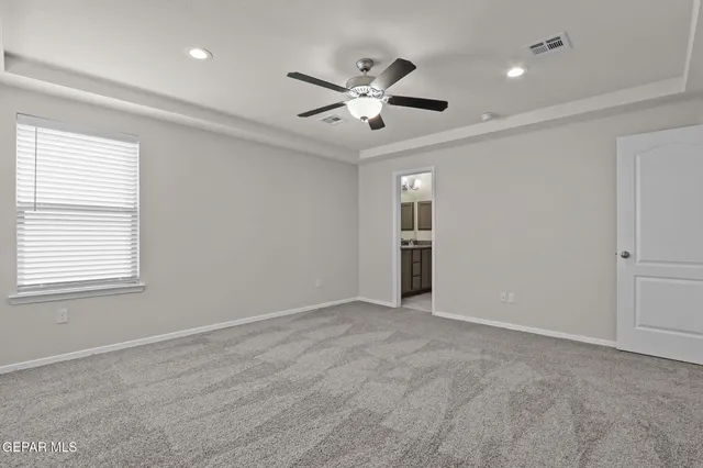 an empty room with windows and fan