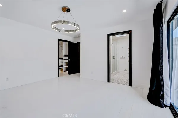 an empty room with closet and a hallway