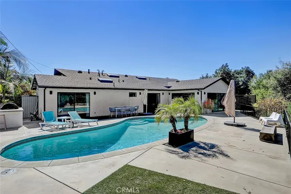 a view of a house with backyard and sitting area