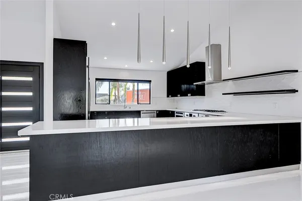 a kitchen with stainless steel appliances a sink dishwasher and a black refrigerator