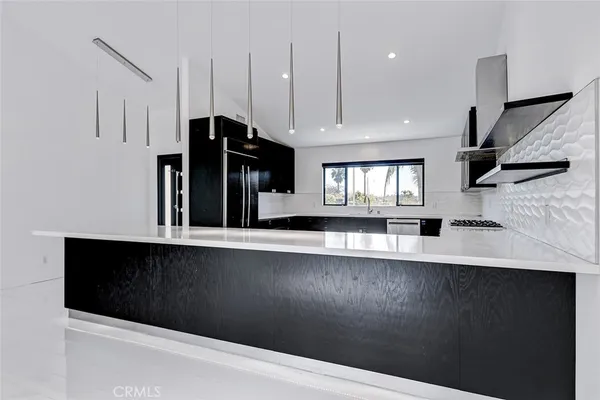 a kitchen with stainless steel appliances a sink a refrigerator and a stove