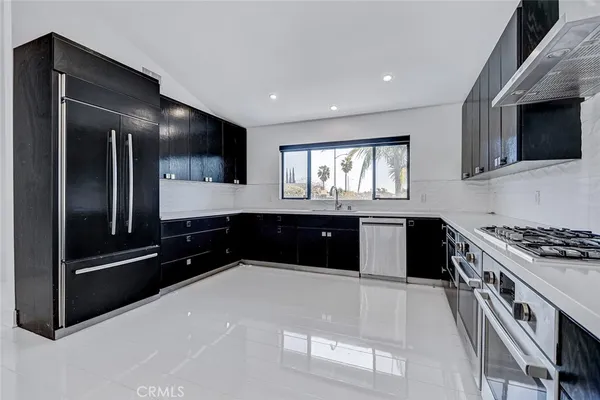 a kitchen with stainless steel appliances kitchen island granite countertop a stove and a sink