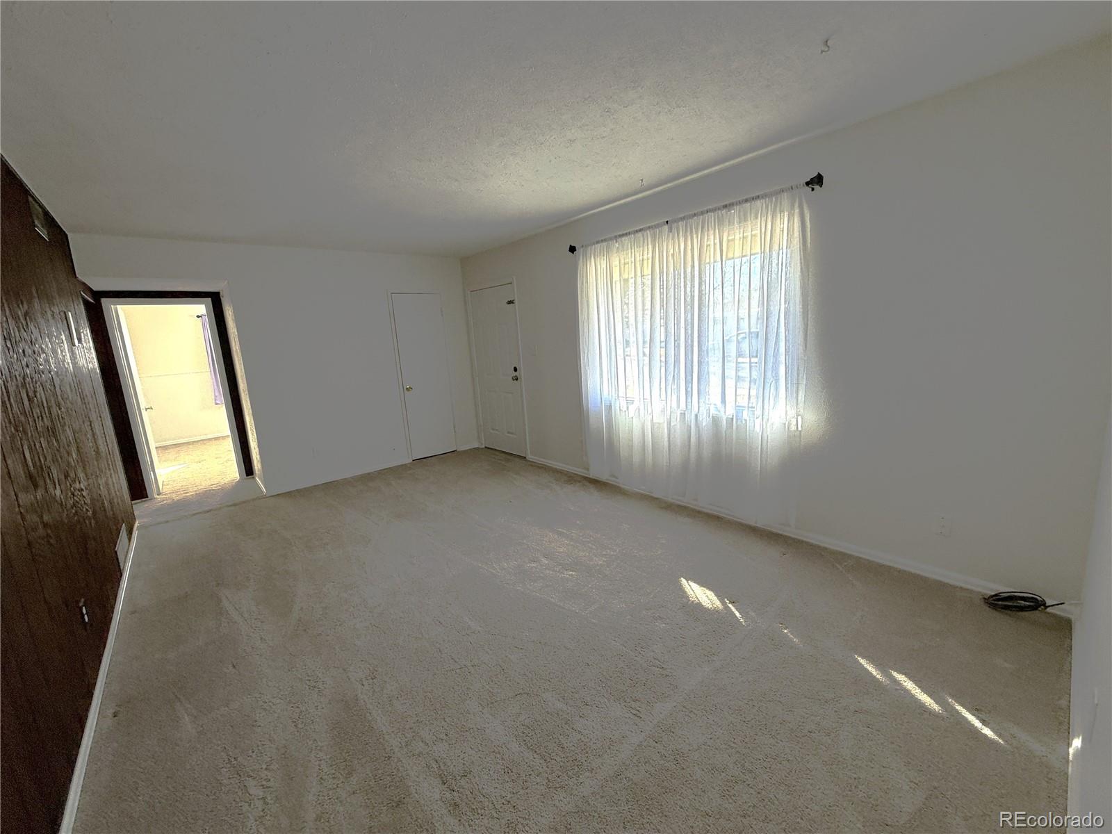 756 Vaughn Street Aurora, CO 80011 - Photo 3 of 22 a view of an empty room with a window